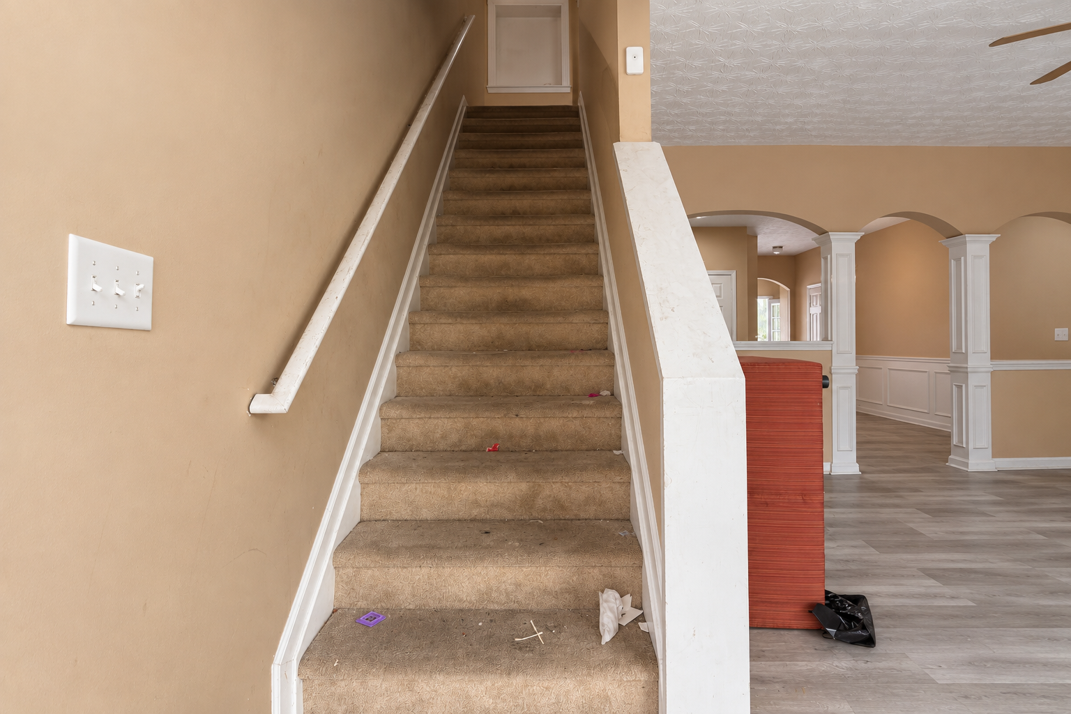 Before renovation showing a carpeted staircase and beige interior walls